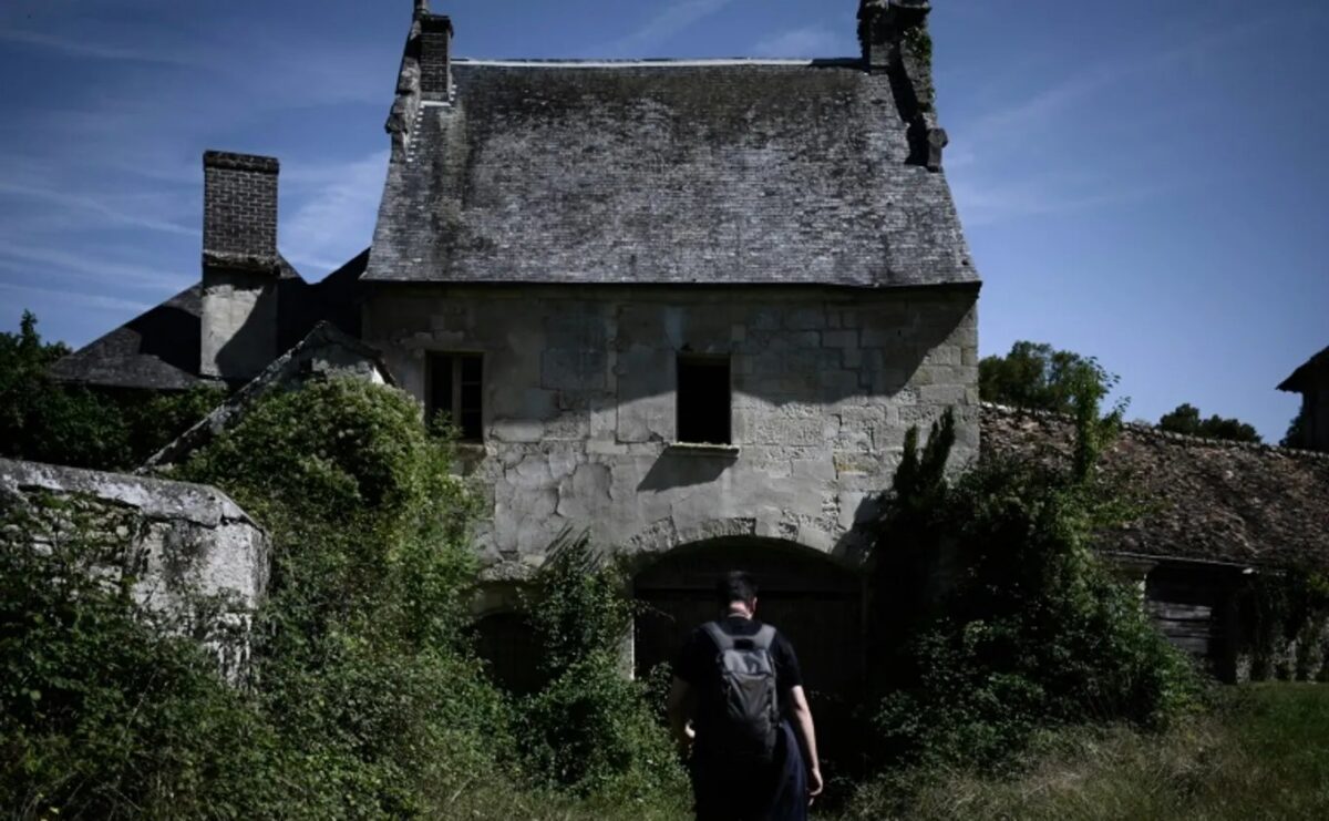 Explorateur urbain photographiant l'intérieur délabré d'un lieu abandonné