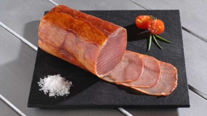 Fines tranches de lomo, longe de porc séchée, disposées sur une planche en bois
