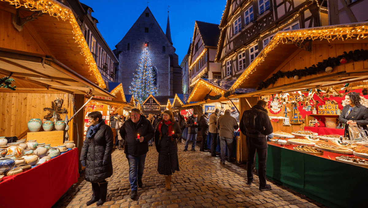 Ruelle alsacienne à colombages illuminée pour Noël avec les chalets d'un marché de Noël