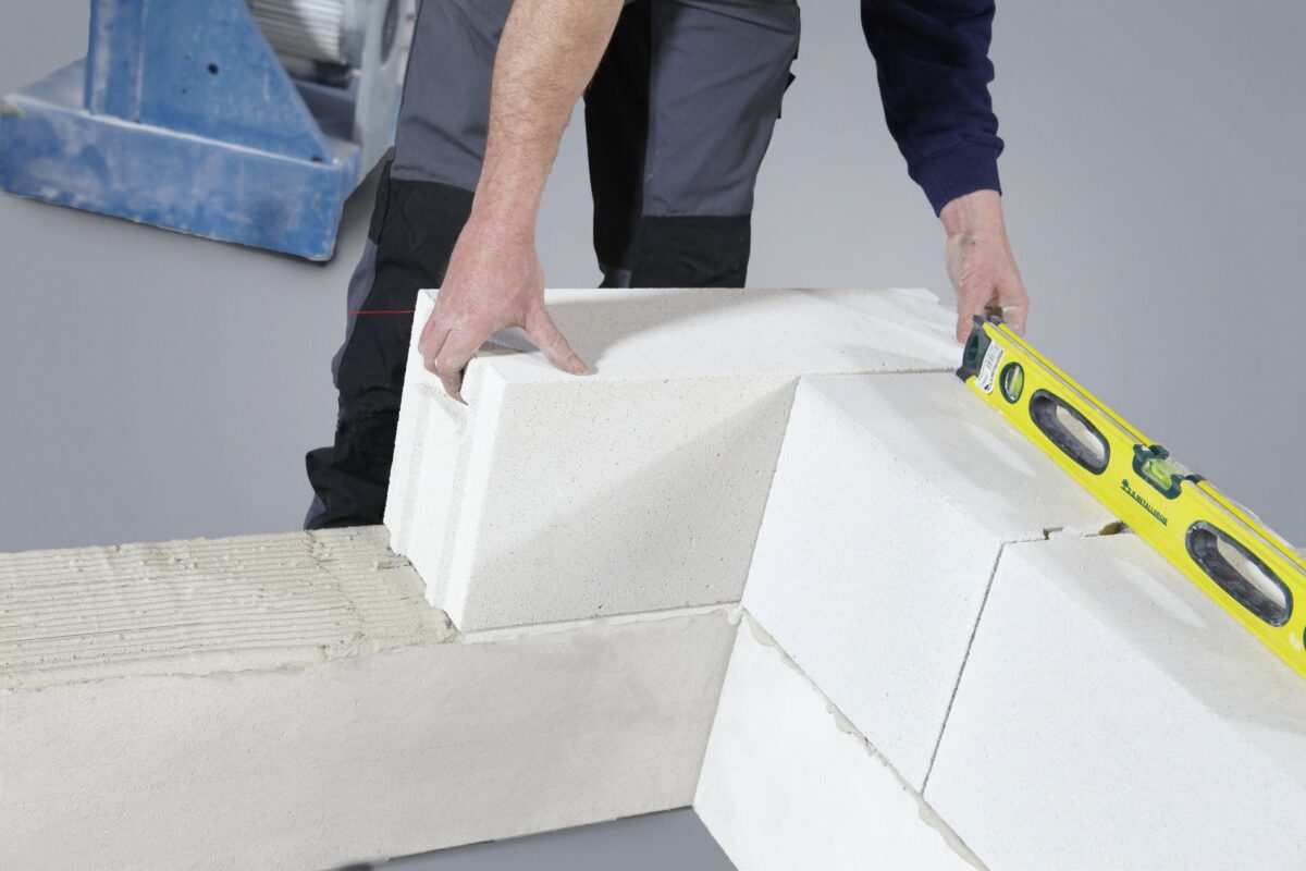 Pose de blocs de parpaing au mortier lors du montage d'un mur