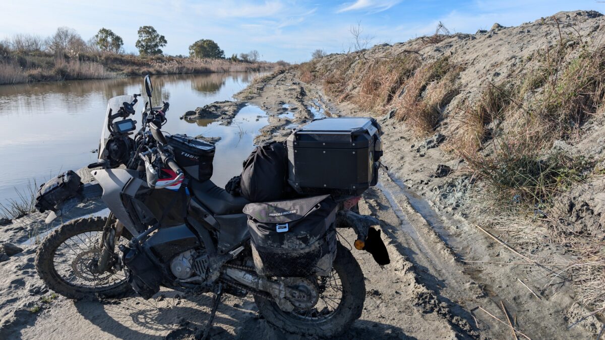 Pièces de moto d'occasion alignées dans une casse, utiles à un voyageur en panne